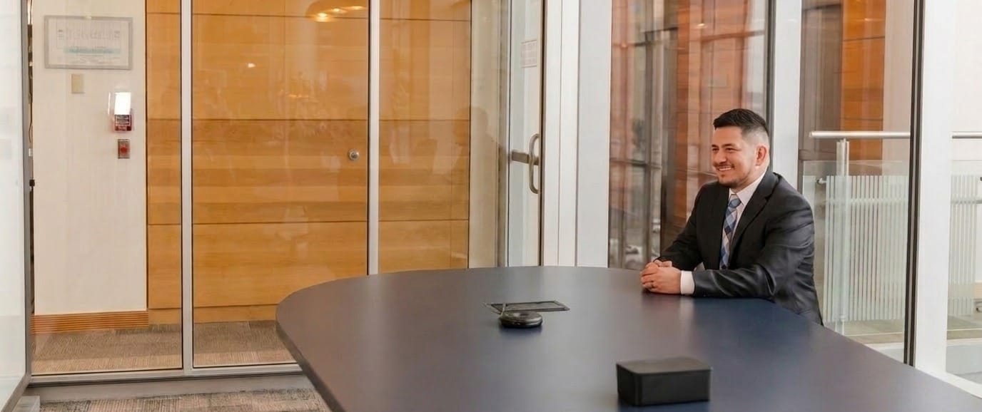 Mosiah Olvera, Owner, Founder, and Attorney at Olvera Law Office, at the conference table in his office