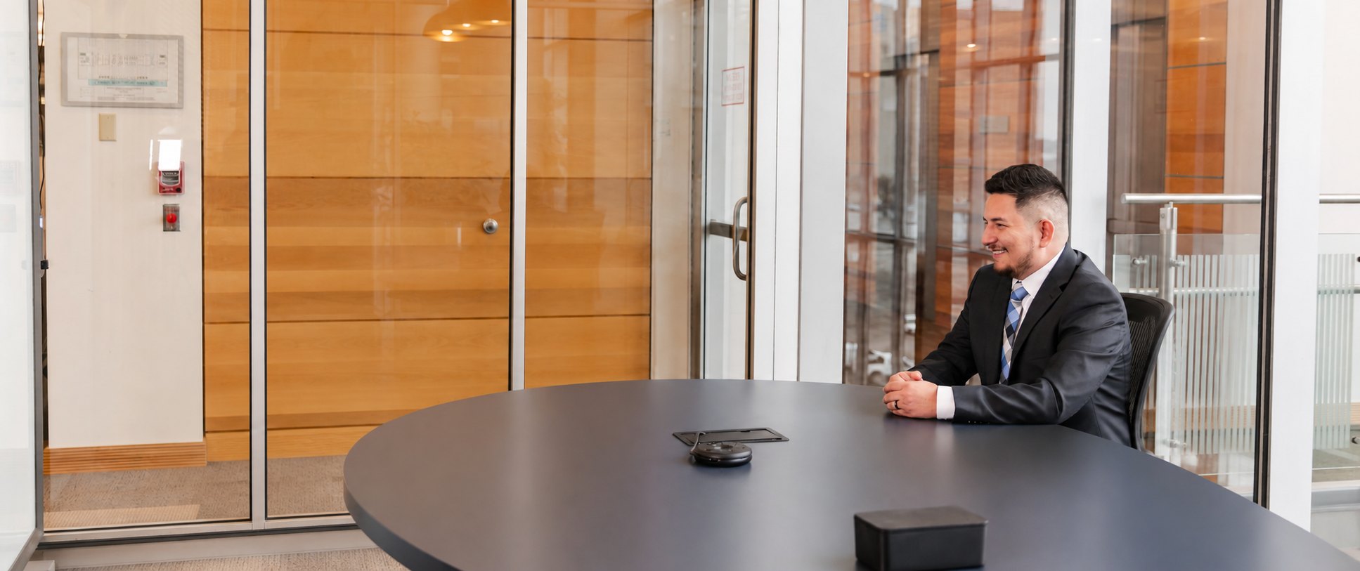 Mosiah Olvera, Owner, Founder, and Attorney at Olvera Law Office, at the conference table in his office