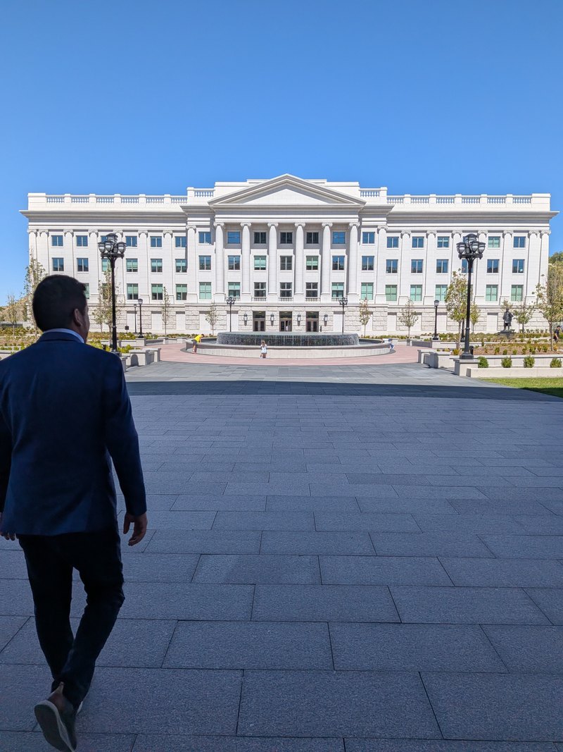 Mosiah Olvera crossing a plaza toward a columned government building